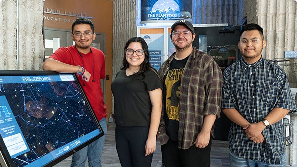 Students standing near an interactive technology display