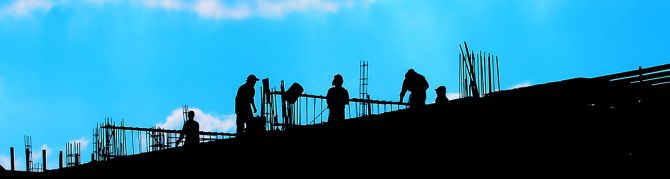 silhouettes of construction people working on a building