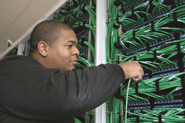 man moving cables on a switch board 