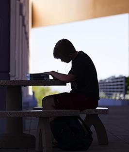 Student doing homework on outdoor patio table