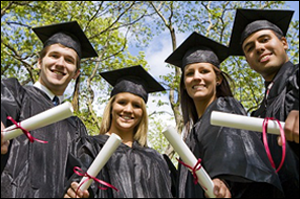 Students holding diplomas at graduation.
