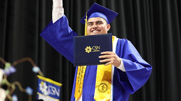 Graduate holding diploma and celebrating on stage