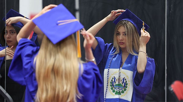 Graduates preparing caps and taking photos backstage