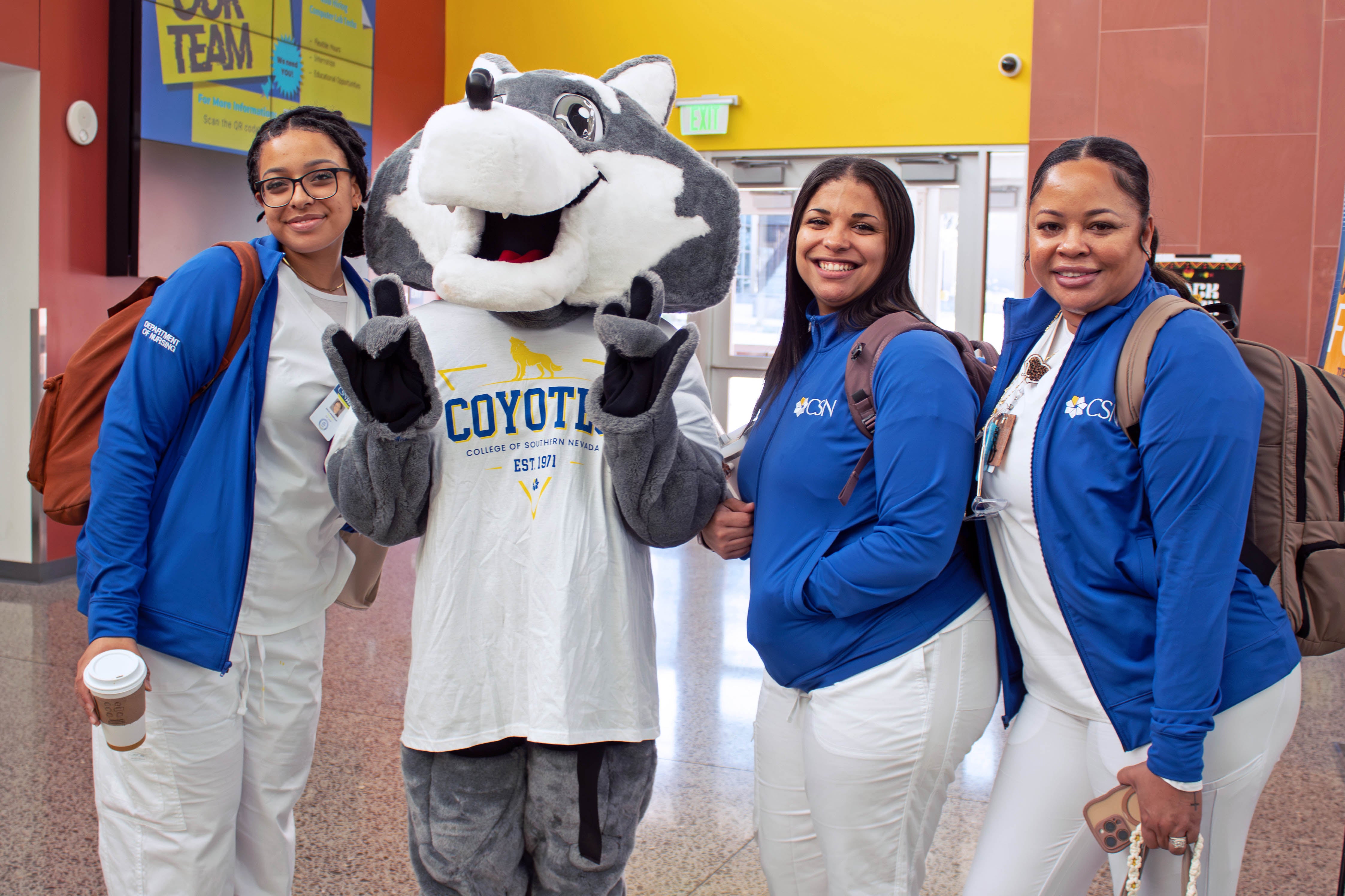 Students smiling with the mascot