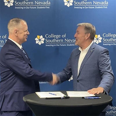 District Court Partnership Signing: President Klippenstein shakes hands with a district court representative during a partnership signing.