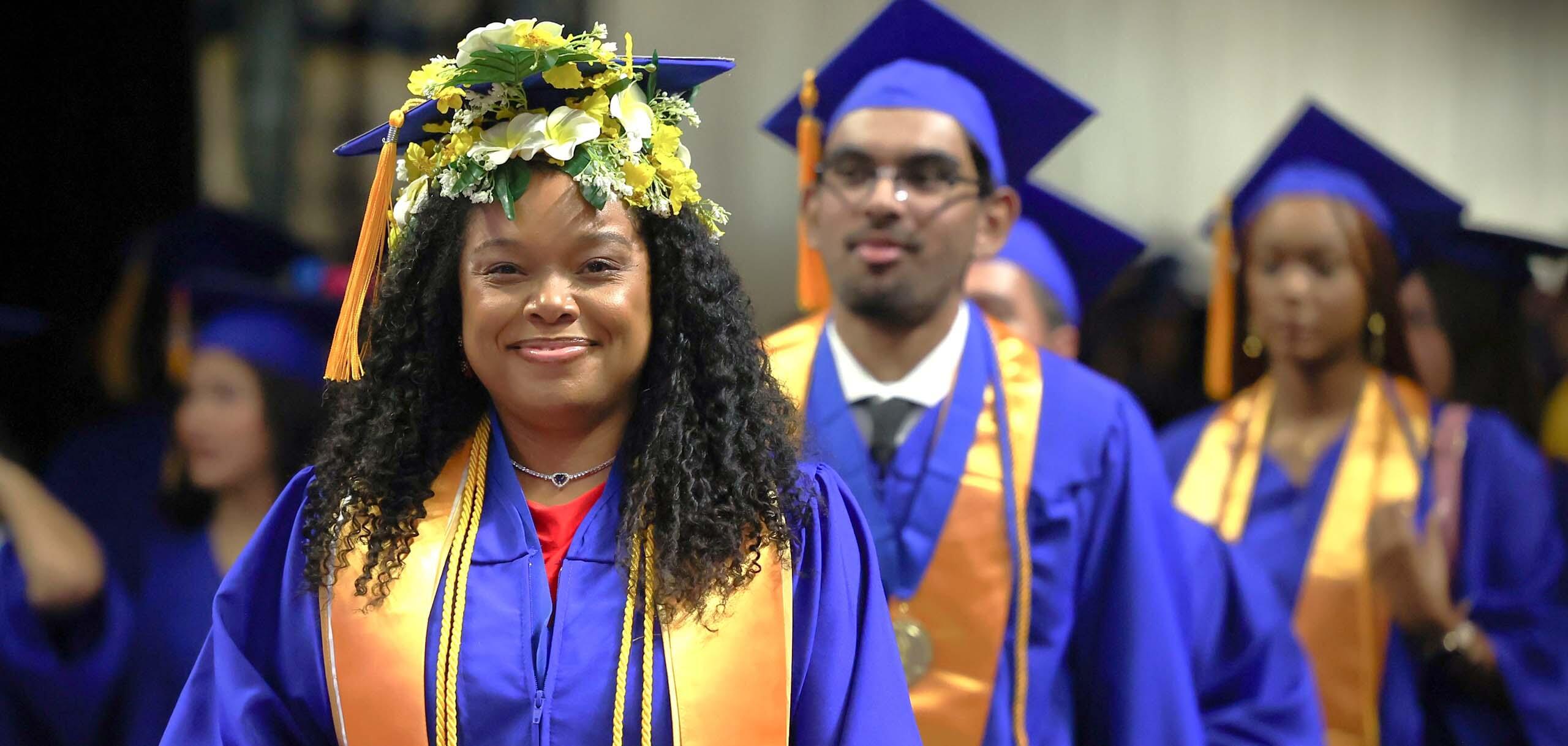 CSN graduates in caps and gowns walking during commencement ceremony.